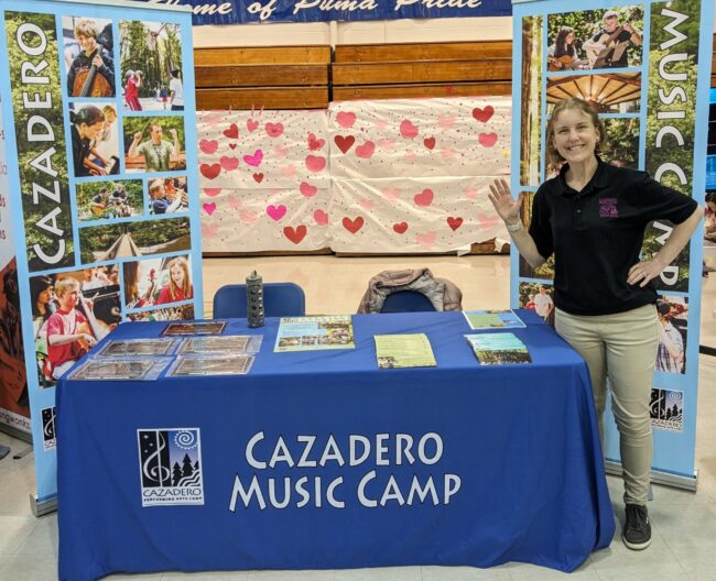 Staff smiling at a camp fair booth