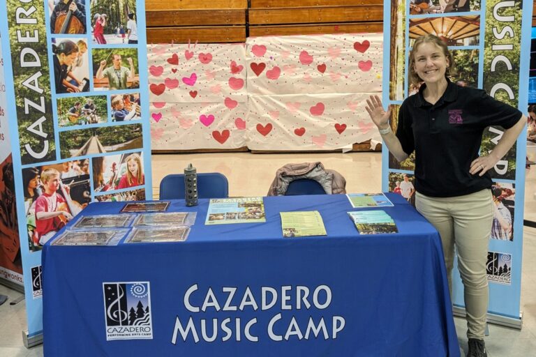 Staff smiling at a camp fair booth